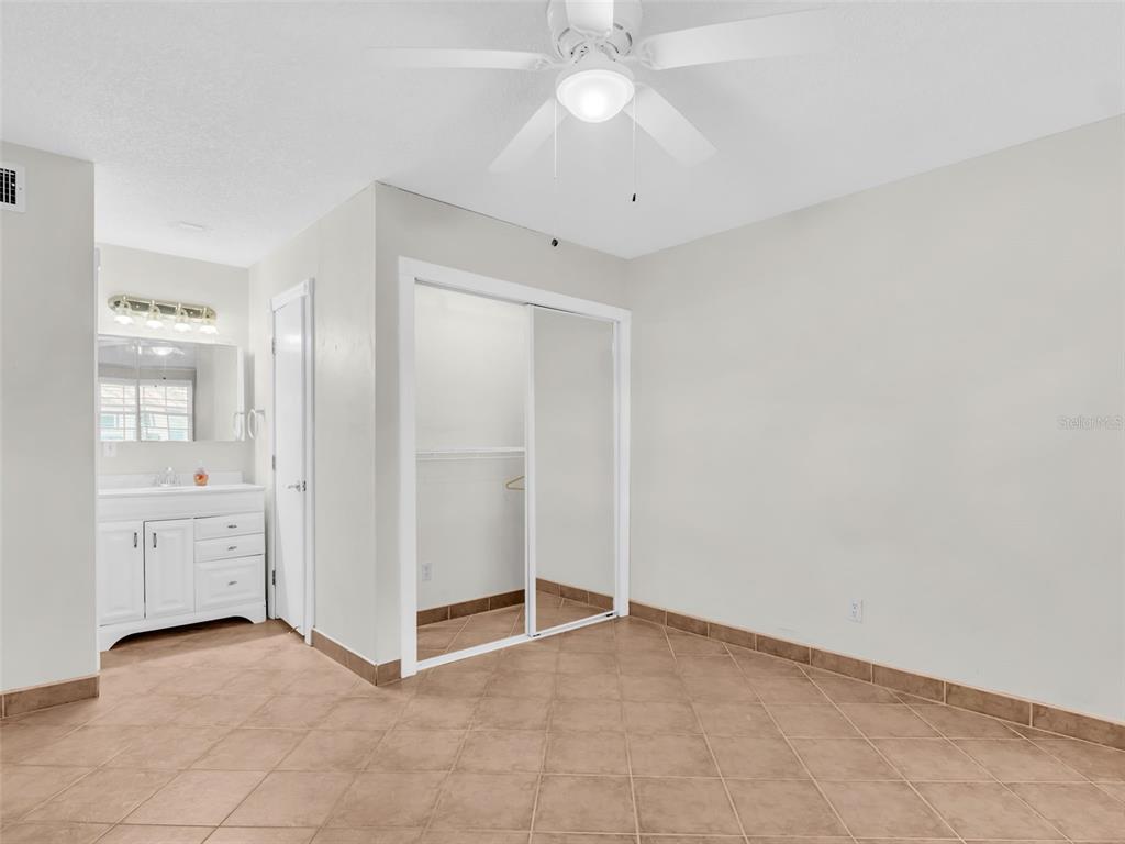 3109 Mission Grove Drive, Unit D Palm Harbor, FL 34684 - Photo 13 of 62 an empty room with chandelier fan and kitchen view
