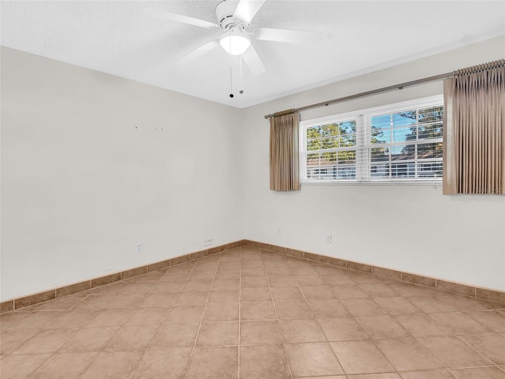 3109 Mission Grove Drive, Unit D Palm Harbor, FL 34684 - Photo 21 of 62 an empty room with a chandelier fan and windows