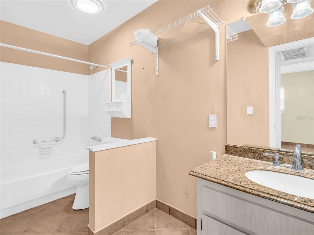 3109 Mission Grove Drive, Unit D Palm Harbor, FL 34684 - Photo 25 of 62 a bathroom with a granite countertop sink a toilet and shower