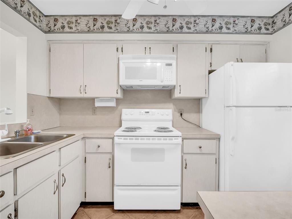 3109 Mission Grove Drive, Unit D Palm Harbor, FL 34684 - Photo 29 of 62 a kitchen with a stove a refrigerator and a sink