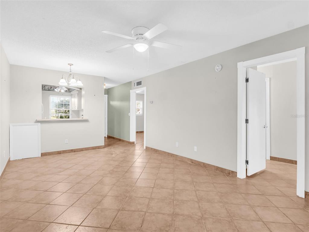3109 Mission Grove Drive, Unit D Palm Harbor, FL 34684 - Photo 7 of 62 an empty room with windows and chandelier fan