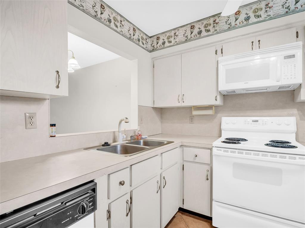 3109 Mission Grove Drive, Unit D Palm Harbor, FL 34684 - Photo 10 of 62 a kitchen with appliances cabinets and a sink