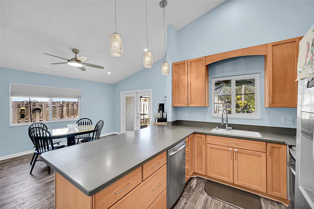 22533 Swordfish Drive Boca Raton, FL 33428 - Photo 11 of 49 a kitchen with stainless steel appliances granite countertop a stove a sink dishwasher a dining table and chairs with wooden floor