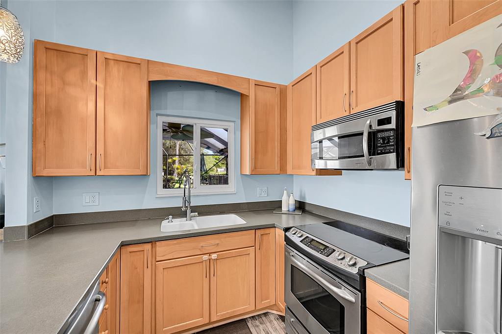 22533 Swordfish Drive Boca Raton, FL 33428 - Photo 12 of 49 a kitchen with stainless steel appliances a sink stove and cabinets