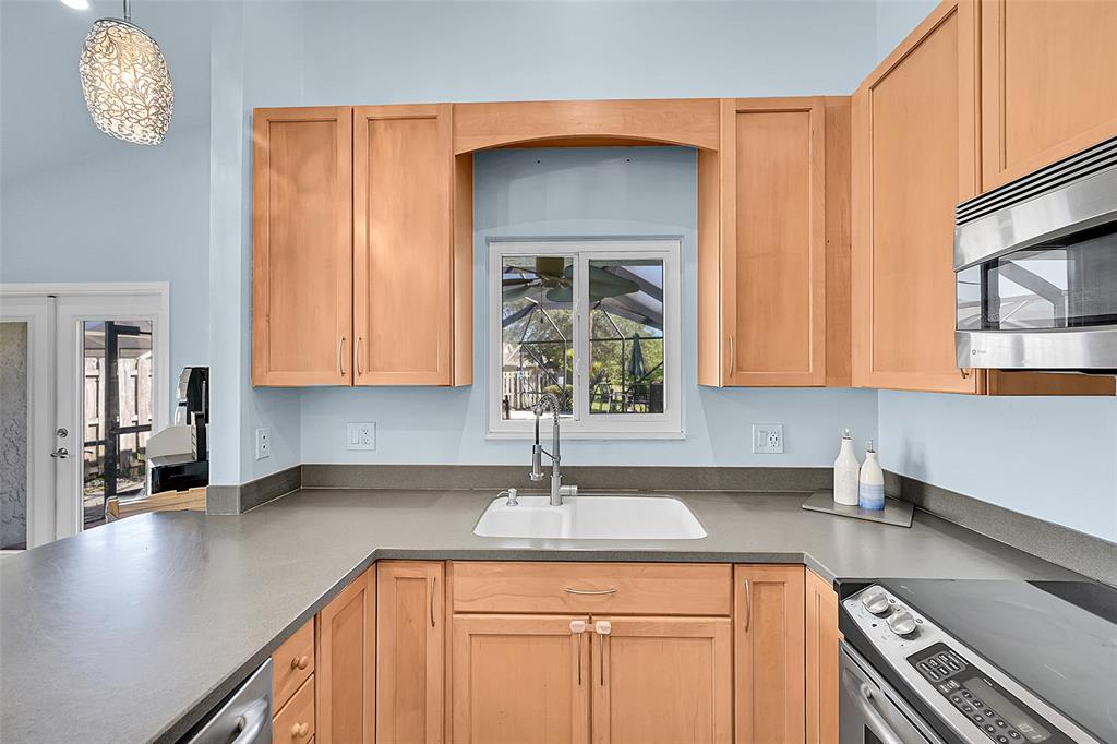 22533 Swordfish Drive Boca Raton, FL 33428 - Photo 13 of 49 a kitchen with stainless steel appliances a sink a stove cabinets and a counter top space