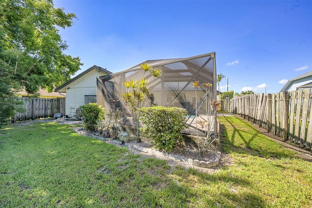 22533 Swordfish Drive Boca Raton, FL 33428 - Photo 32 of 49 a view of backyard with wooden fence and large trees
