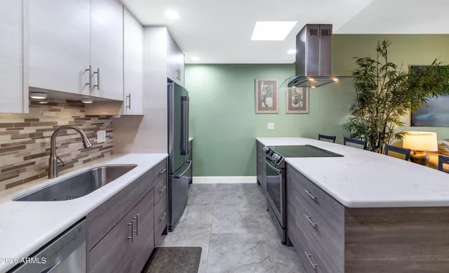 a kitchen with stainless steel appliances granite countertop a sink and a stove