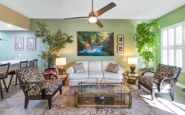 a living room with furniture a chandelier and a rug