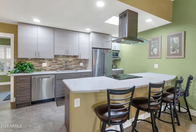 a kitchen with a table chairs refrigerator and cabinets