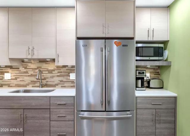 a kitchen with appliances a refrigerator and cabinets