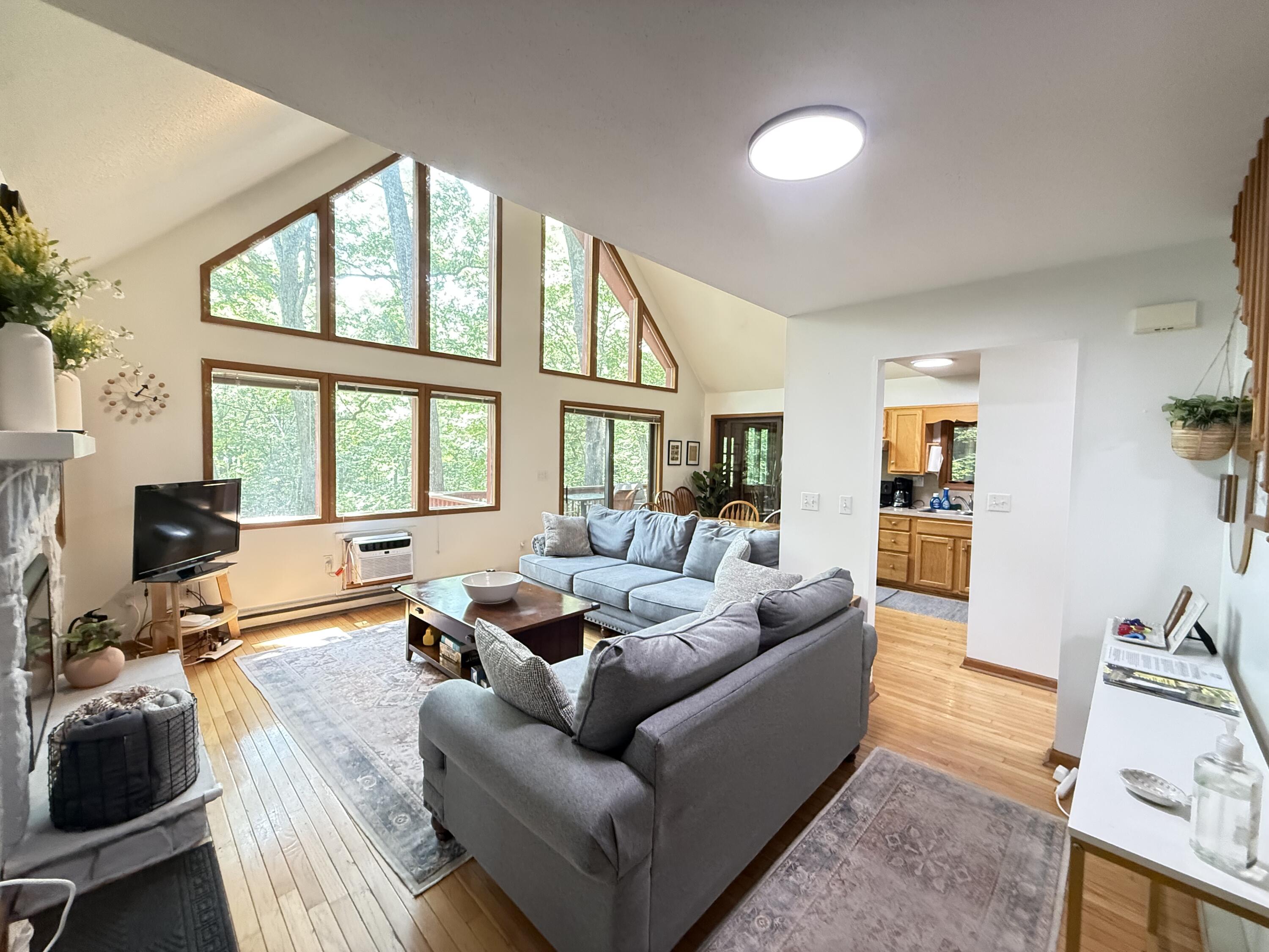 6414 Decker Road Bushkill, PA 18324 - Photo 6 of 65 a living room with furniture a flat screen tv and a large window