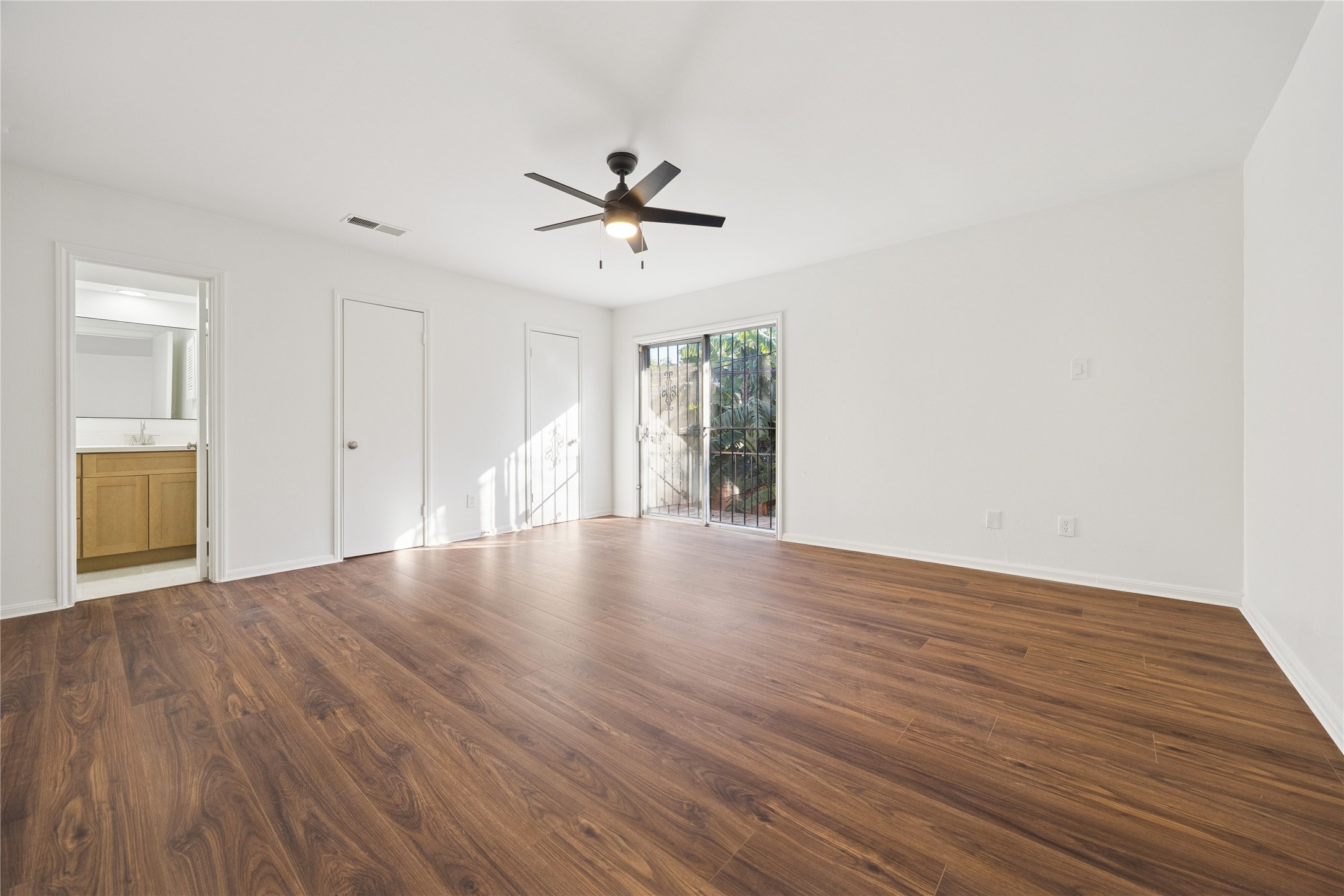 705 Harold Street, Unit 1 Houston, TX 77006 - Photo 11 of 16 a view of an empty room with wooden floor and a ceiling fan