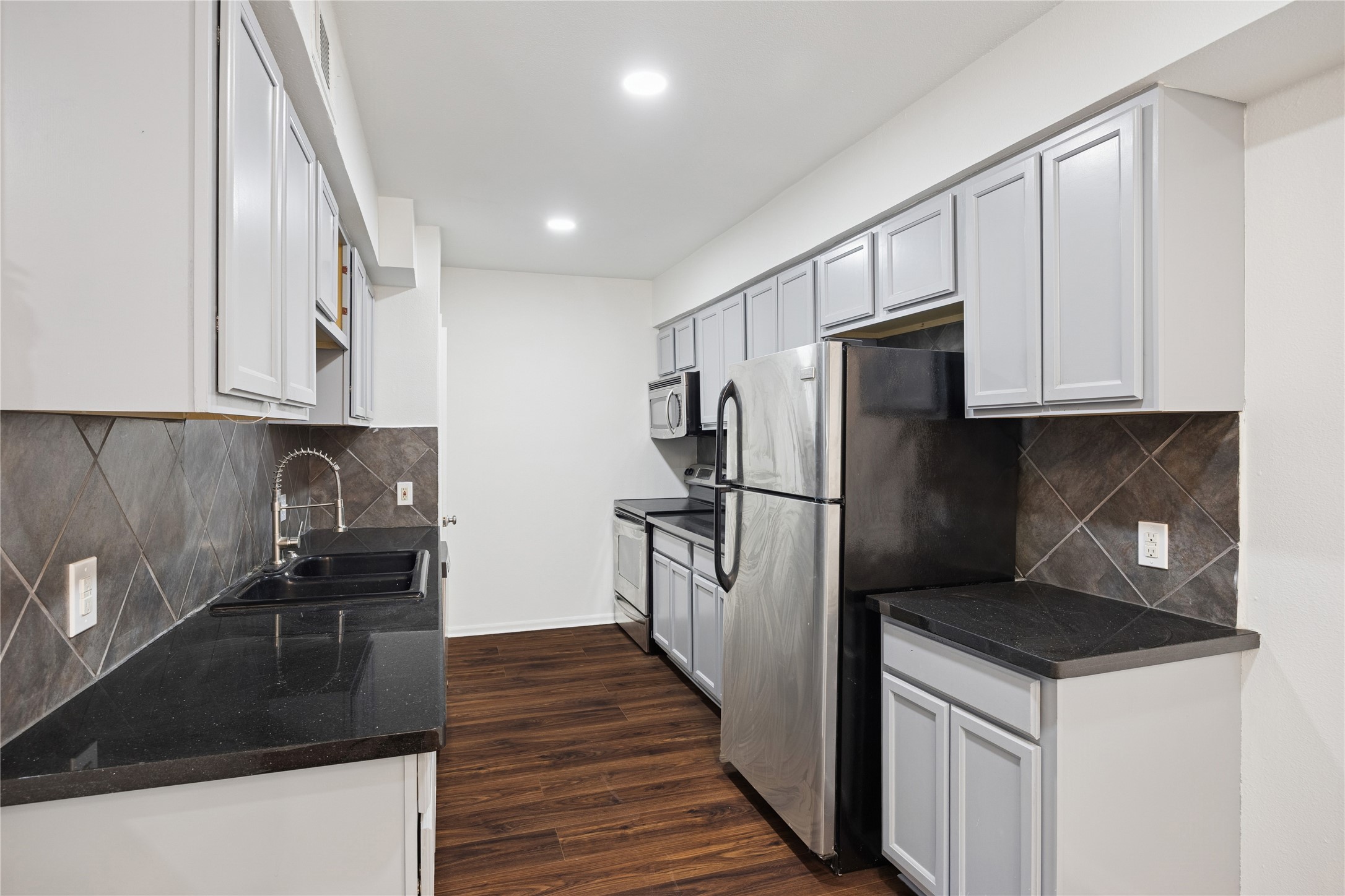705 Harold Street, Unit 1 Houston, TX 77006 - Photo 5 of 16 a kitchen with a refrigerator stove and wooden cabinets