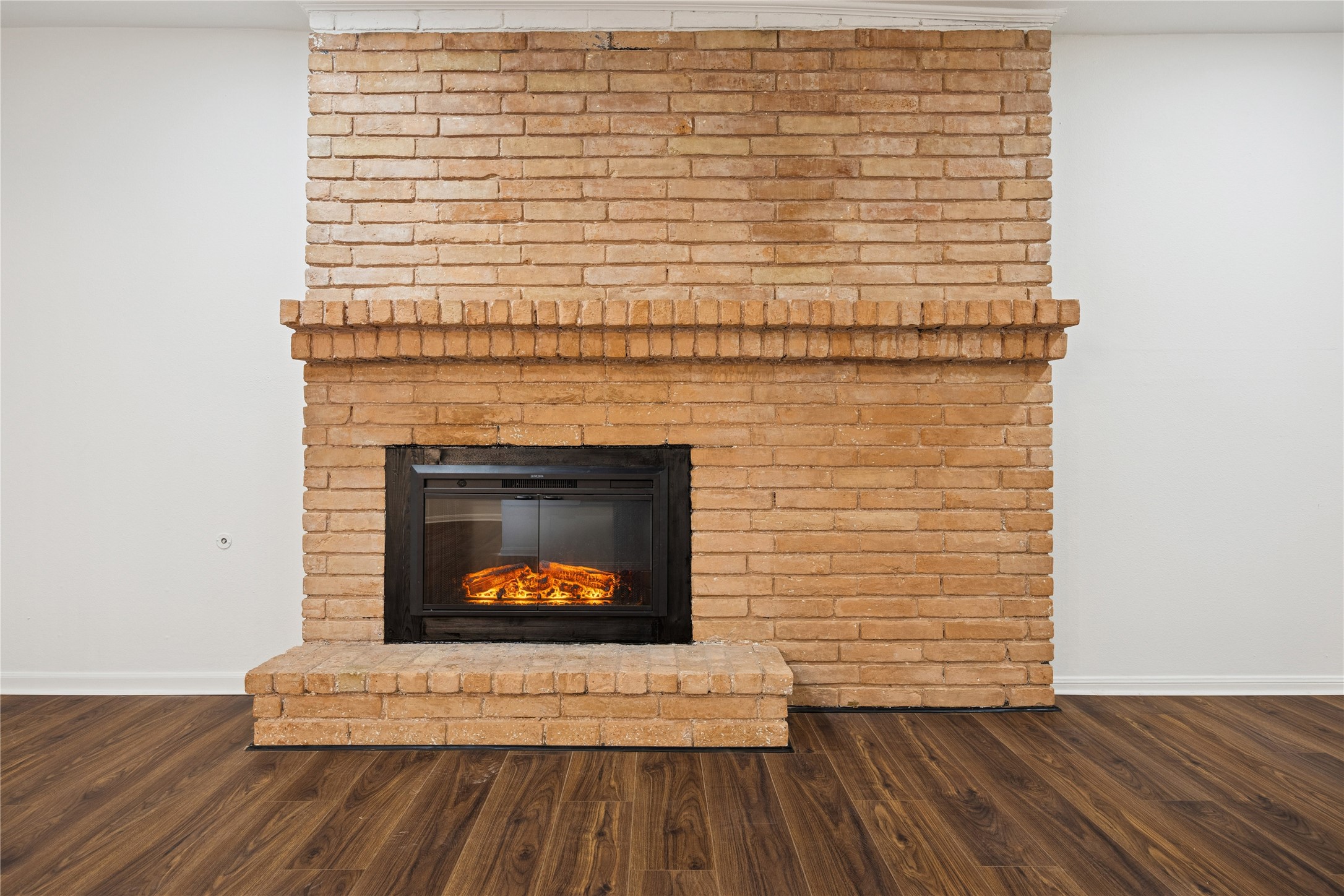 705 Harold Street, Unit 1 Houston, TX 77006 - Photo 7 of 16 a view of an empty room with wooden floor a fireplace and a window