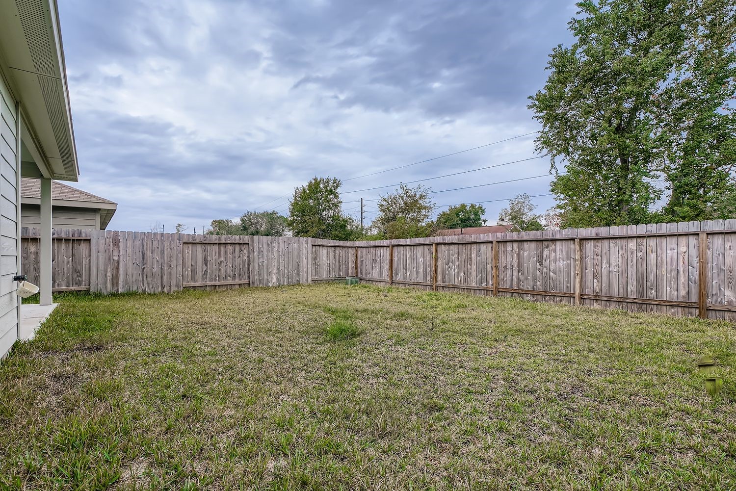 1726 Windstone Ridge Drive Houston, TX 77014 - Photo 28 of 28 a view of a backyard with wooden fence