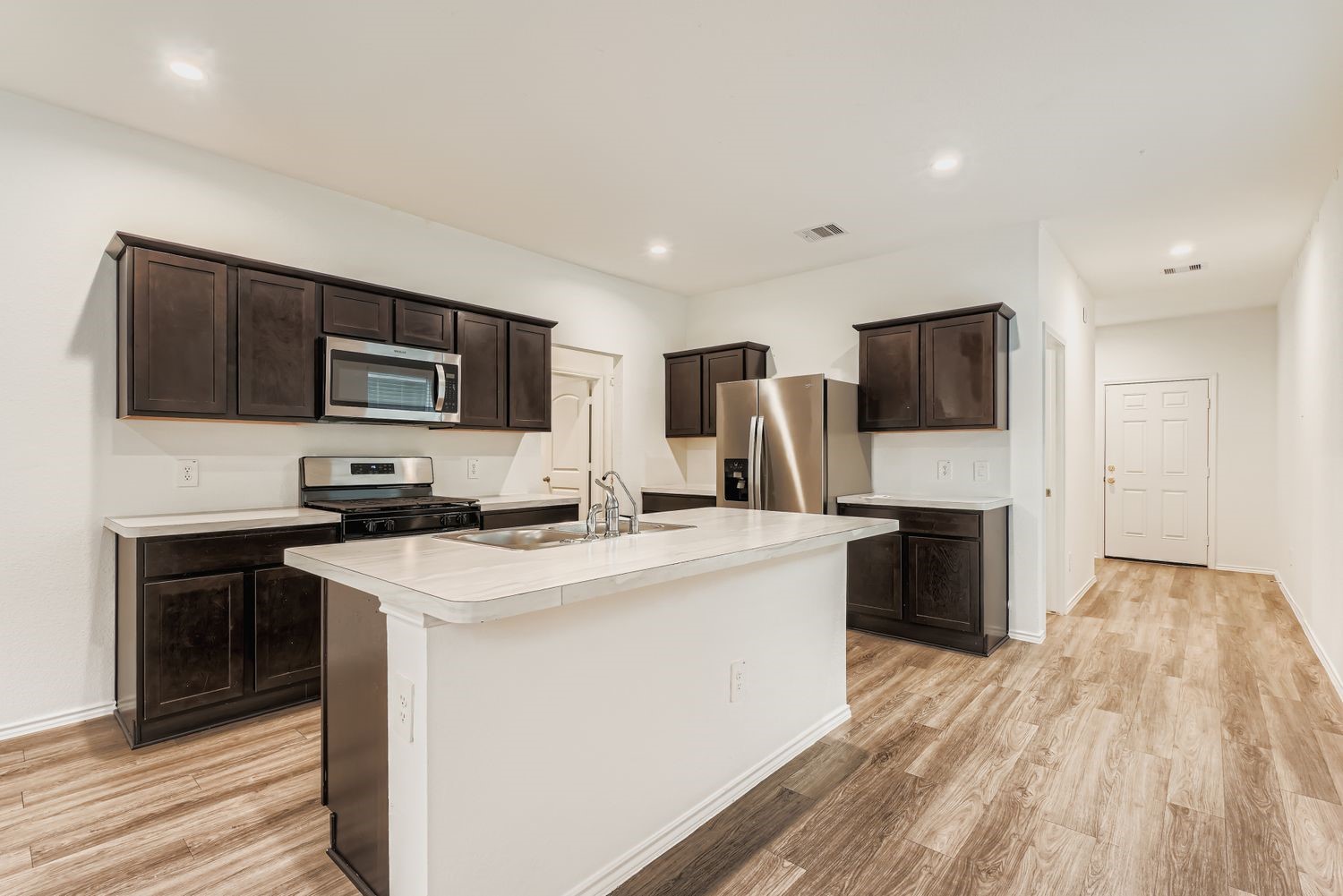 1726 Windstone Ridge Drive Houston, TX 77014 - Photo 7 of 28 a kitchen with a stove a sink and a microwave