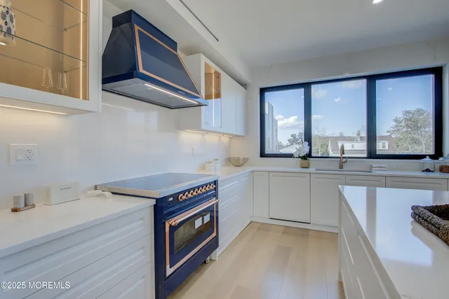 a kitchen that has a sink a stove and cabinets