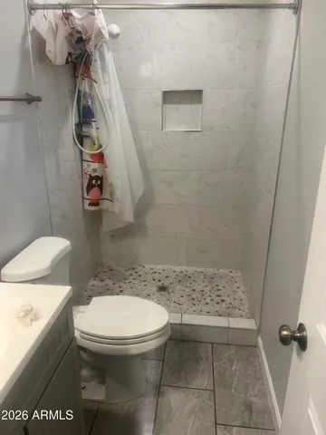 a bathroom with a toilet and a shower