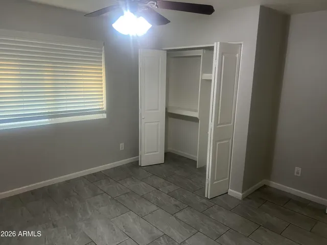 an empty room with windows and closet
