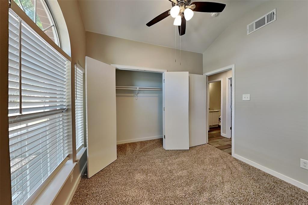 4920 Mountain Ridge Lane McKinney, TX 75071 - Photo 12 of 19 Unfurnished bedroom with light carpet, multiple windows, a ceiling fan, a closet, and lofted ceiling