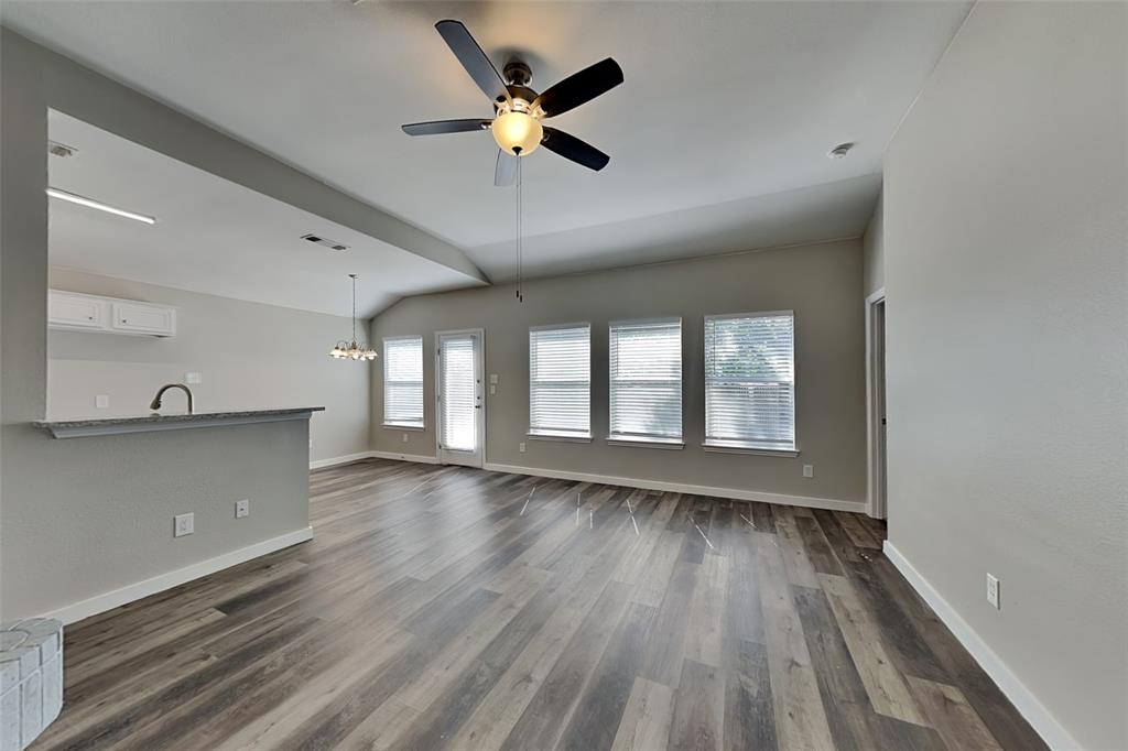 4920 Mountain Ridge Lane McKinney, TX 75071 - Photo 2 of 19 Unfurnished living room with dark wood-style flooring, a chandelier, a ceiling fan, and lofted ceiling
