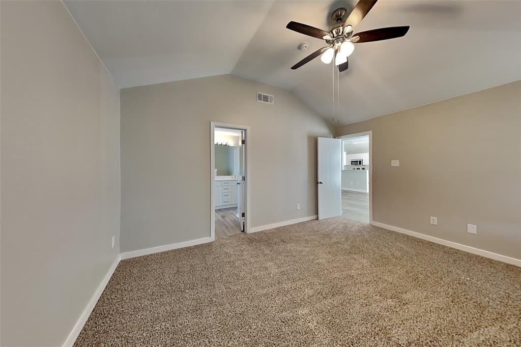 4920 Mountain Ridge Lane McKinney, TX 75071 - Photo 7 of 19 Unfurnished bedroom featuring vaulted ceiling, carpet floors, a ceiling fan, and connected bathroom