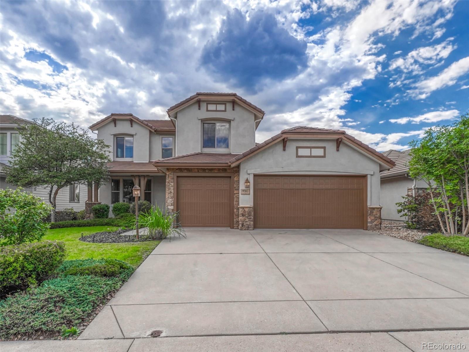 9741 Sunset Hill Circle Lone Tree, CO 80124 - Photo 1 of 43 a front view of house with yard and trees