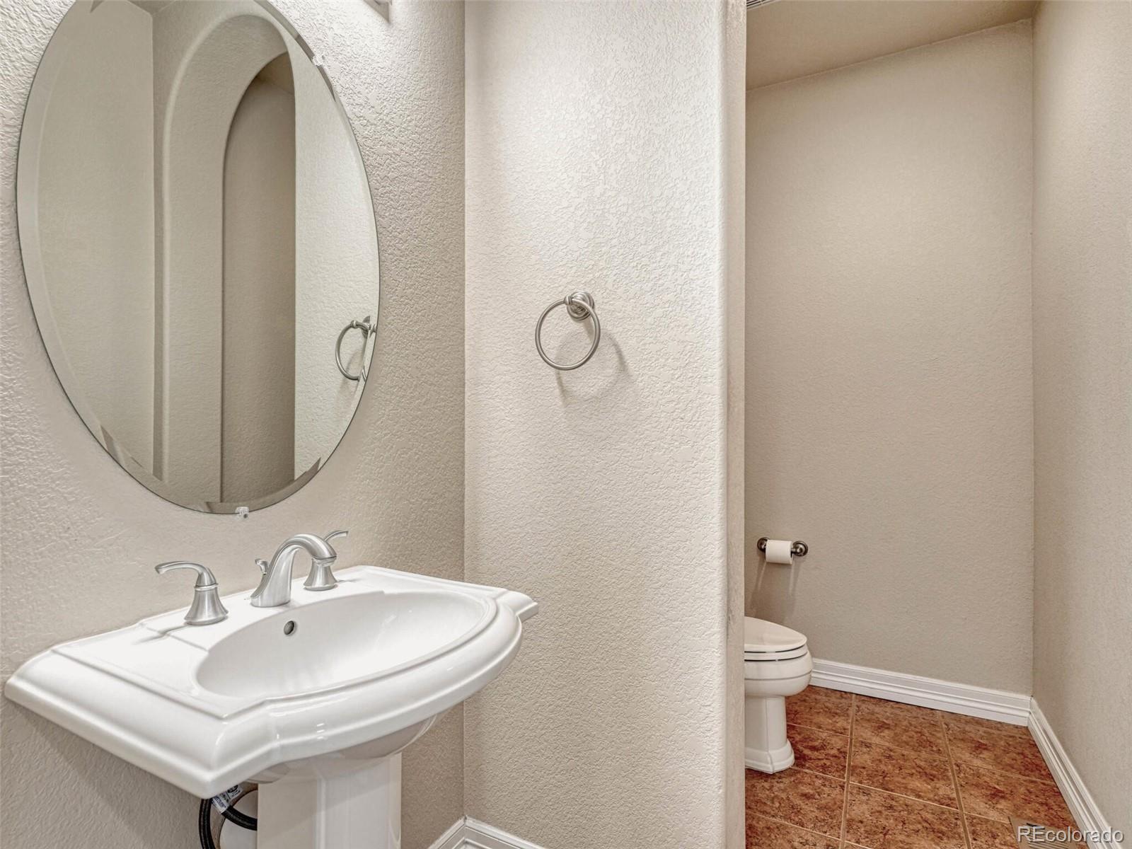 9741 Sunset Hill Circle Lone Tree, CO 80124 - Photo 17 of 43 a bathroom with a sink and mirror with toilet