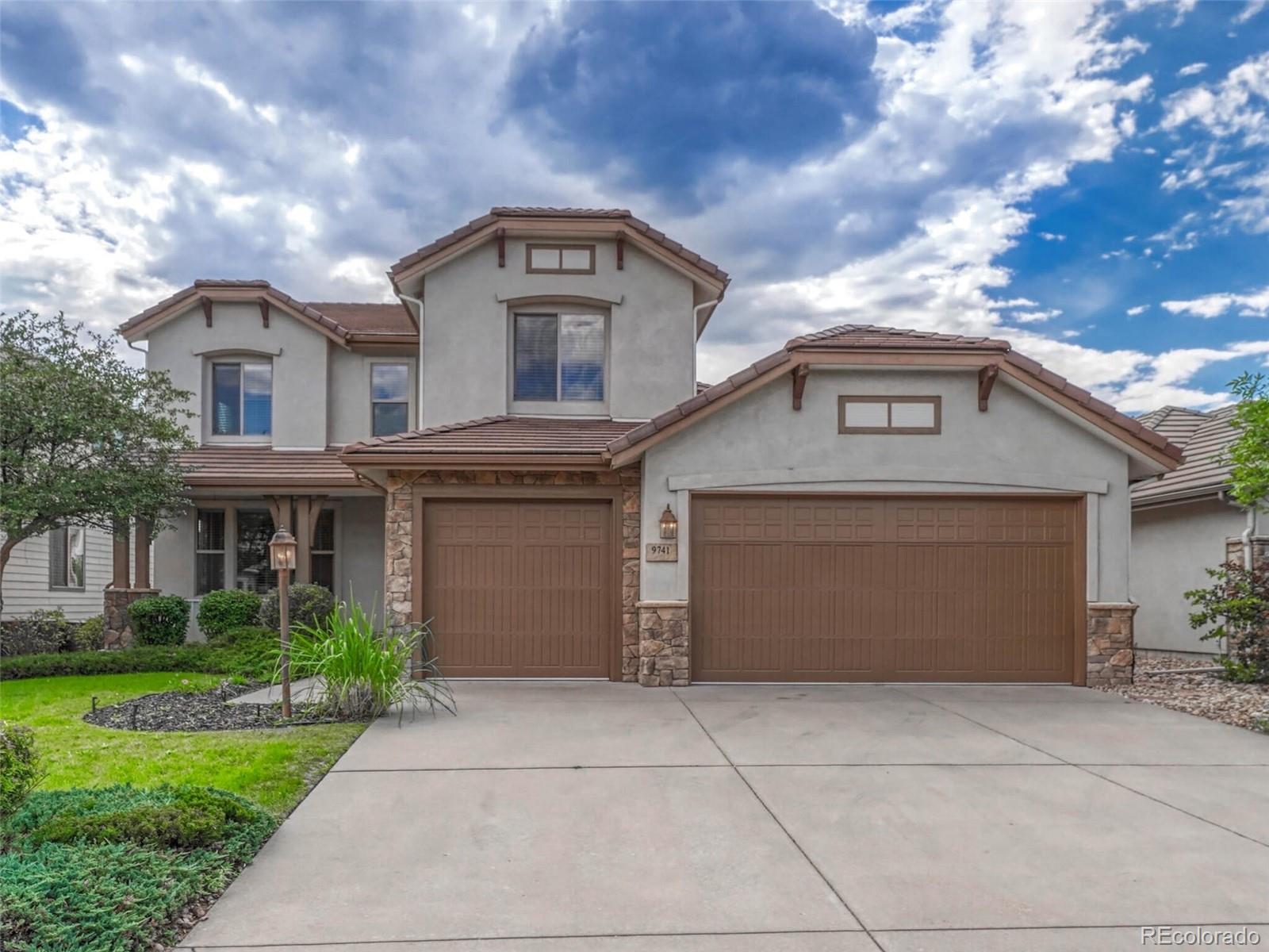 9741 Sunset Hill Circle Lone Tree, CO 80124 - Photo 2 of 43 a front view of a house with garden