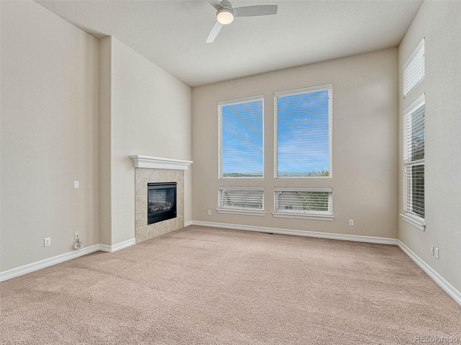 9741 Sunset Hill Circle Lone Tree, CO 80124 - Photo 21 of 43 a view of an empty room with a fireplace and a window