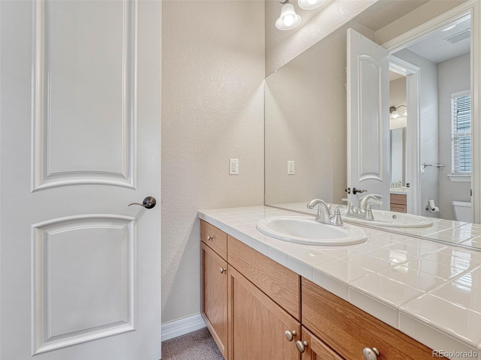 9741 Sunset Hill Circle Lone Tree, CO 80124 - Photo 31 of 43 a bathroom with a sink and a mirror