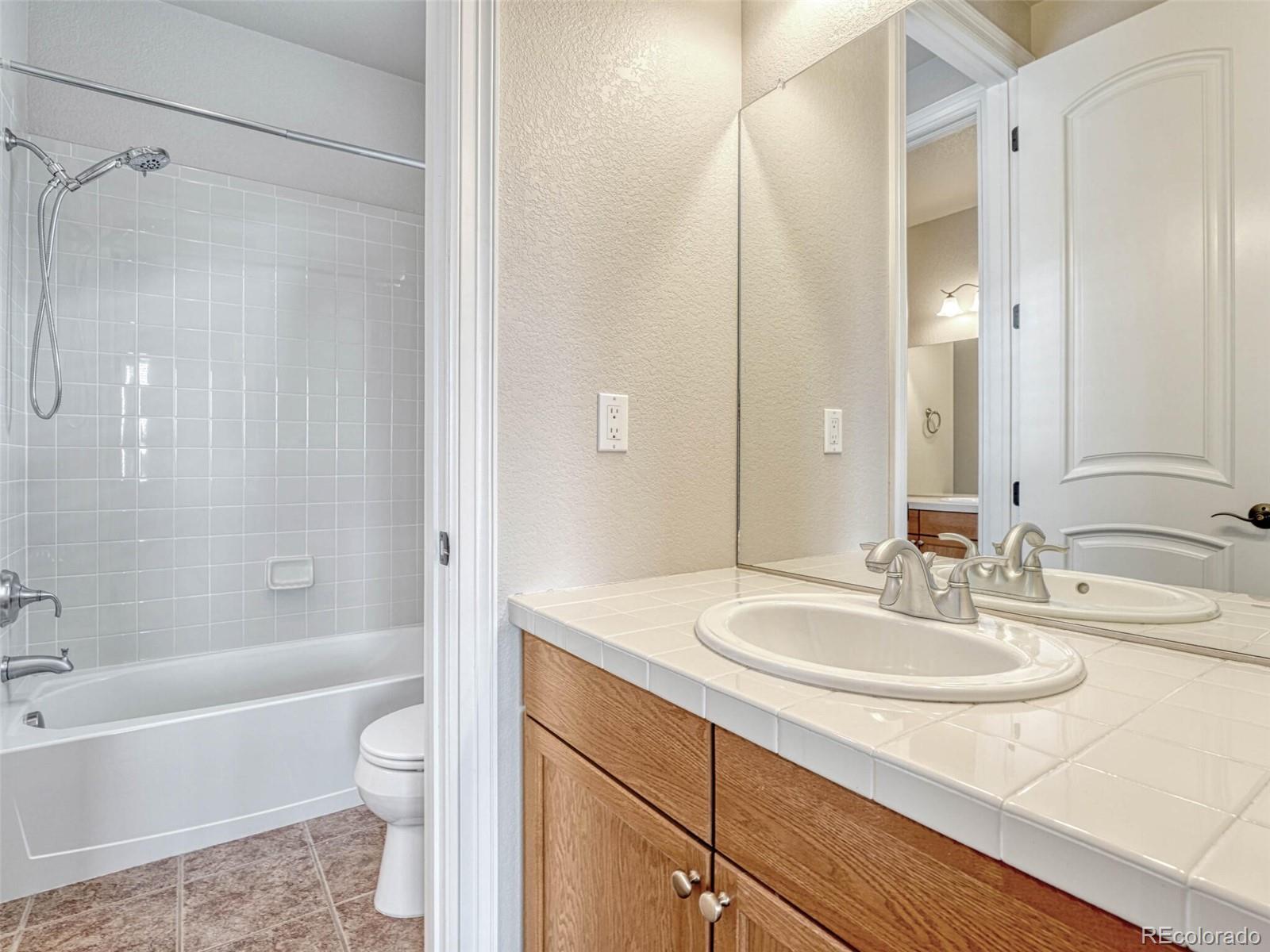 9741 Sunset Hill Circle Lone Tree, CO 80124 - Photo 32 of 43 a bathroom with a sink toilet a shower and a mirror