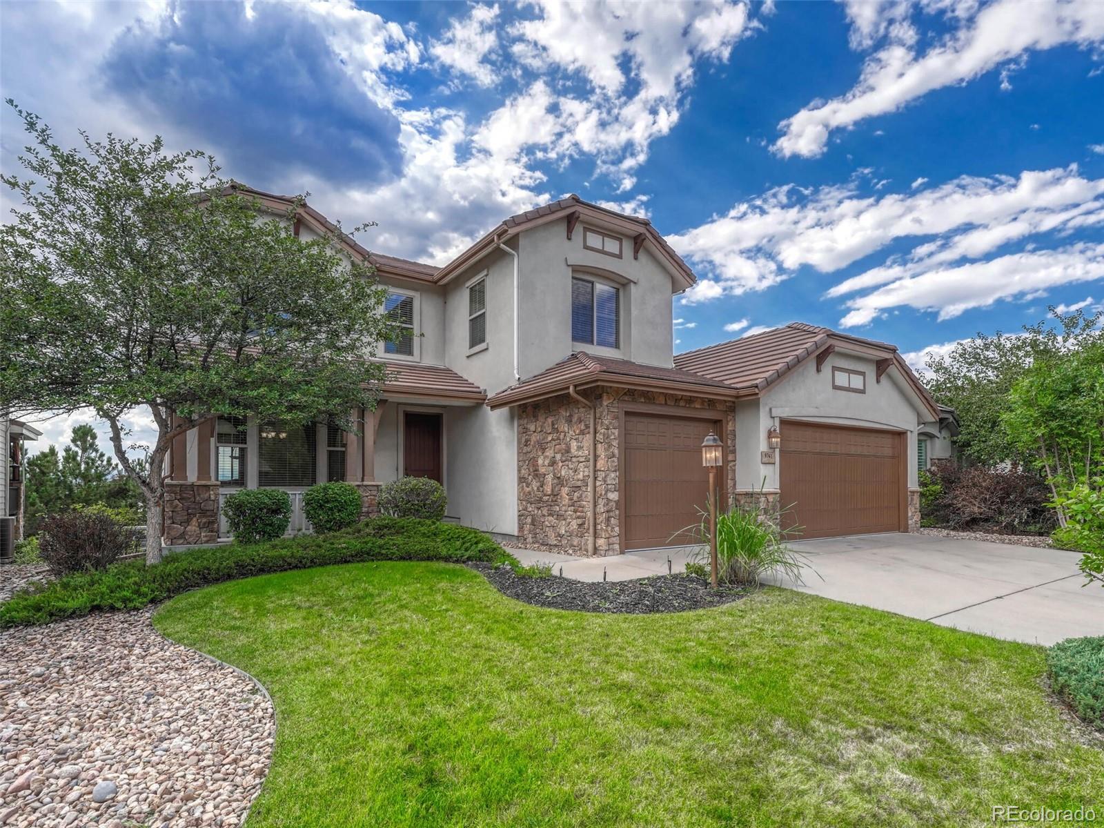 9741 Sunset Hill Circle Lone Tree, CO 80124 - Photo 43 of 43 a front view of a house with a garden and plants