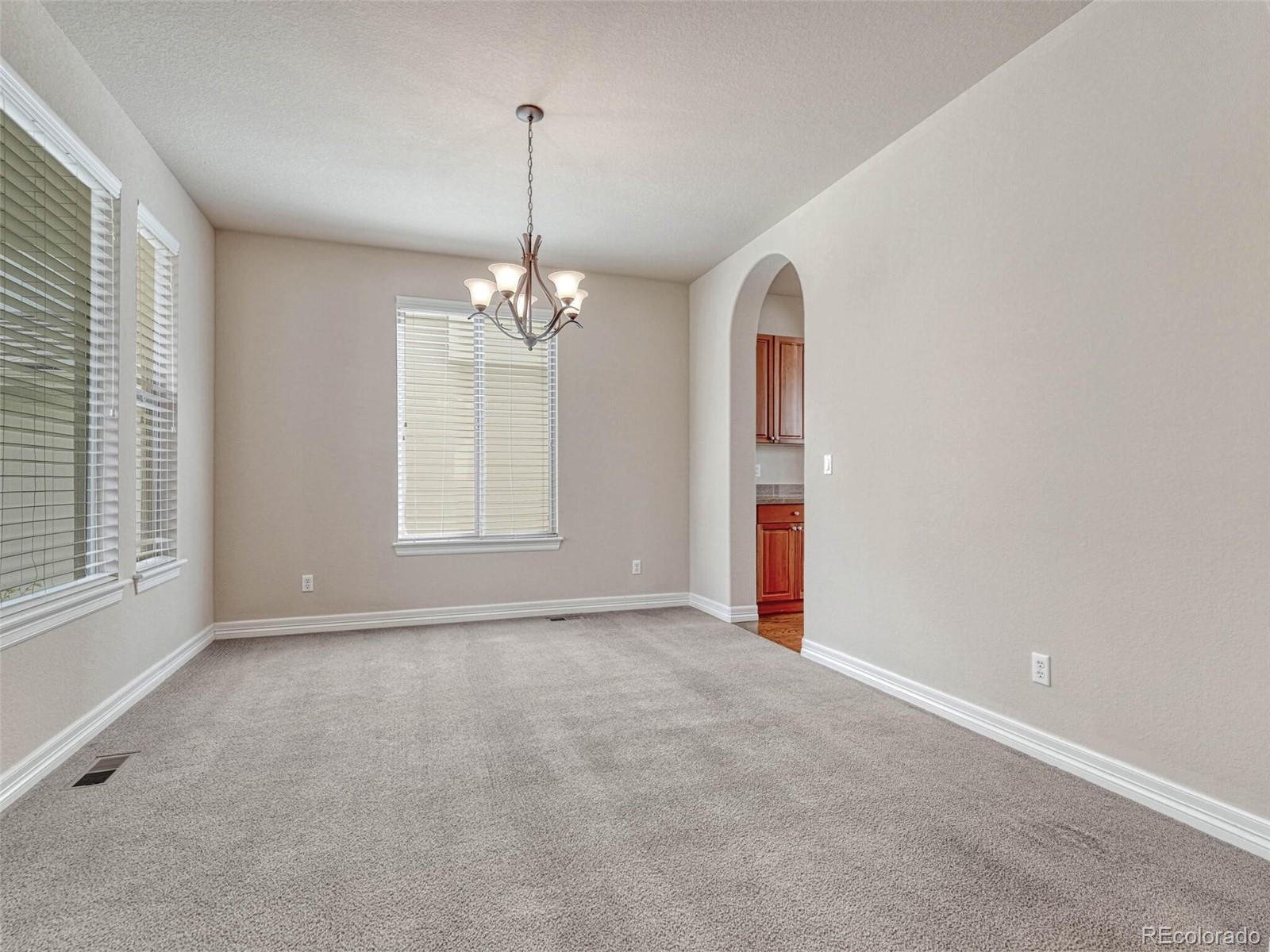9741 Sunset Hill Circle Lone Tree, CO 80124 - Photo 5 of 43 a view of an empty room with window and chandelier fan