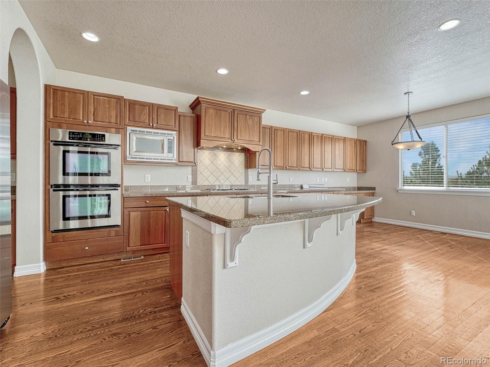 9741 Sunset Hill Circle Lone Tree, CO 80124 - Photo 8 of 43 a kitchen with stainless steel appliances granite countertop a sink and a stove top oven