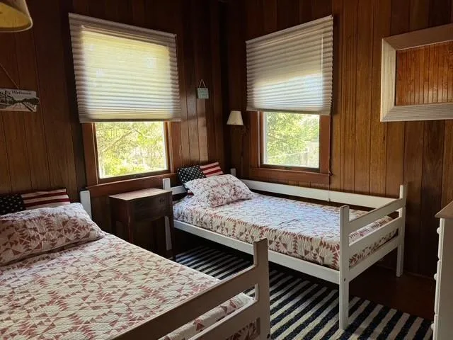 a bedroom with a bed and two windows
