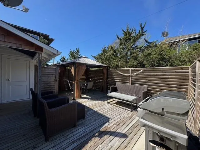 a view of a roof deck with couches and wooden floor