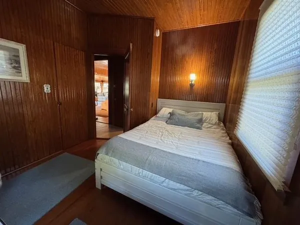 a bedroom with a bed a lamp and paintings on the wall