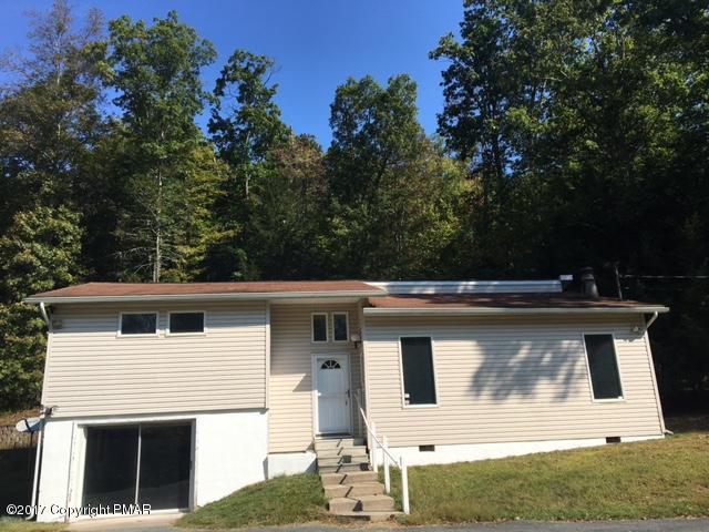567 Snow Hill Road Cresco, PA 18326 - Photo 1 of 17 a view of a white house with large windows and a small yard