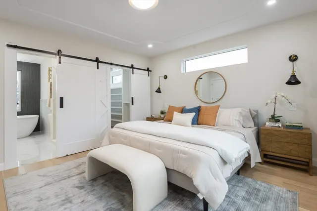 a bedroom with a bed and closet with mirror