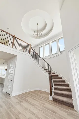 a view of staircase with railing and white walls