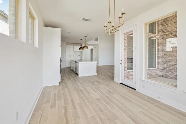a view of empty room with wooden floor and window