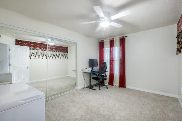 a view of a bedroom with workspace and a window