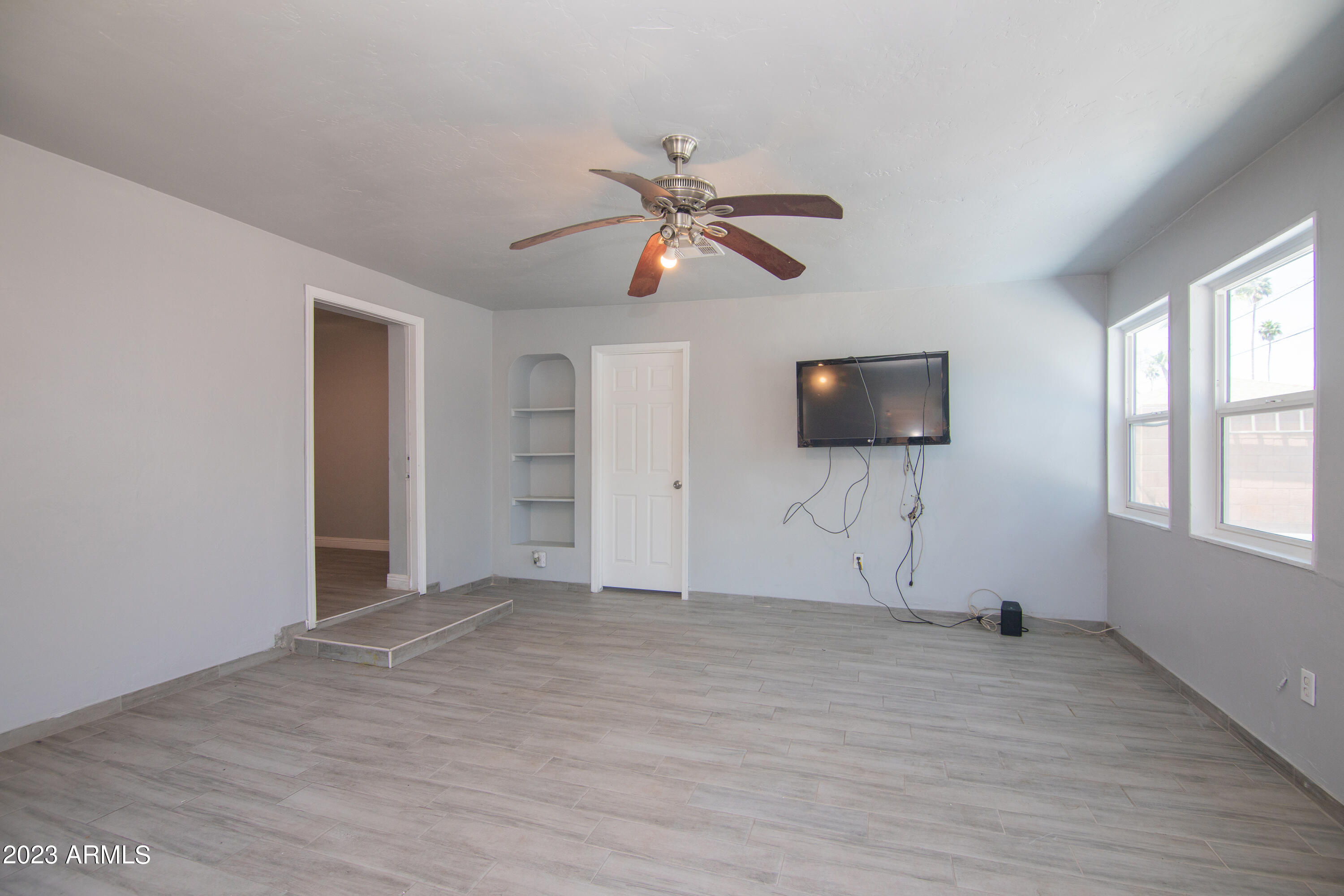1318 East Granada Road Phoenix, AZ 85006 - Photo 12 of 38 a view of a livingroom with a flat screen tv ceiling fan and window