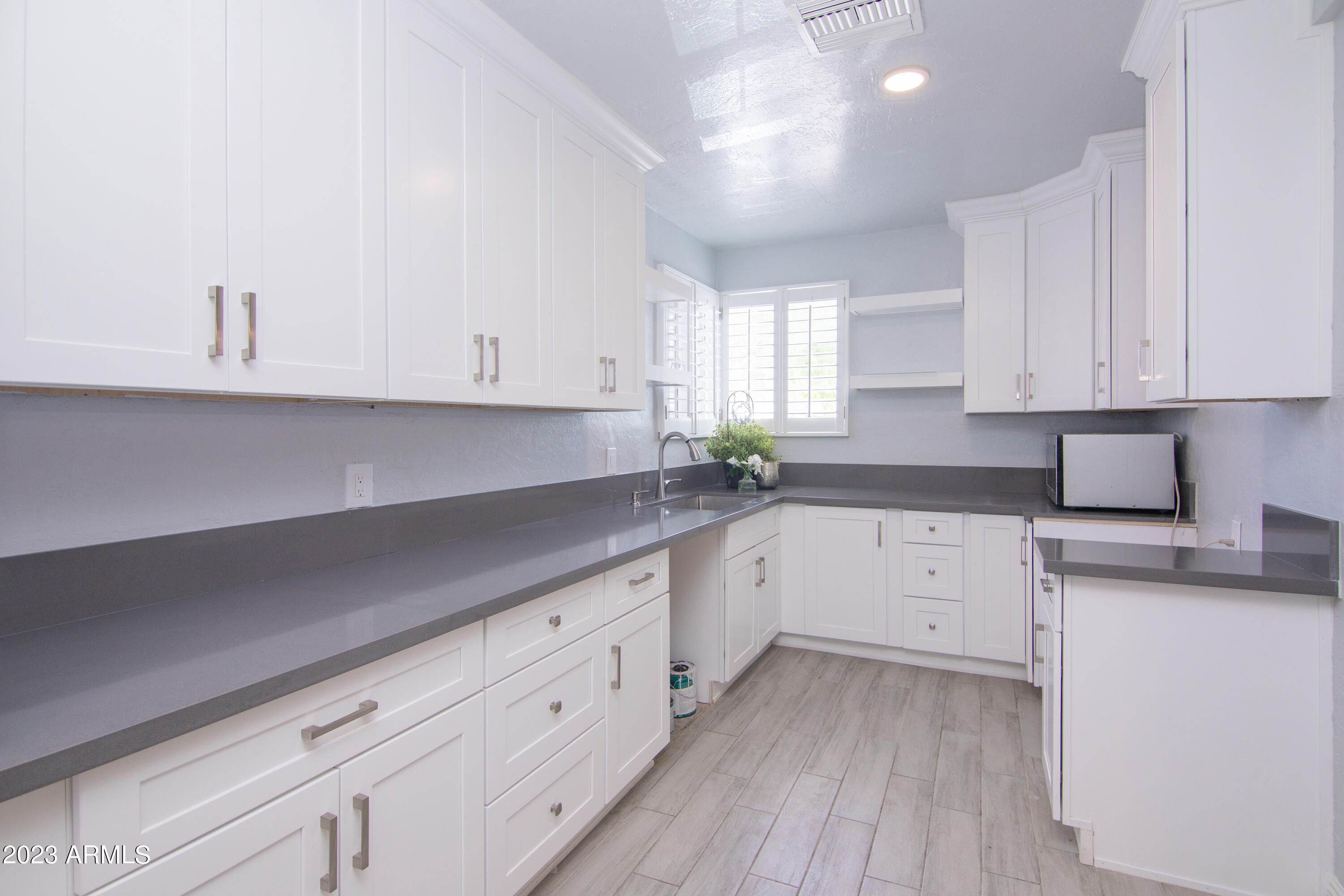 1318 East Granada Road Phoenix, AZ 85006 - Photo 15 of 38 a kitchen with granite countertop white cabinets and white appliances
