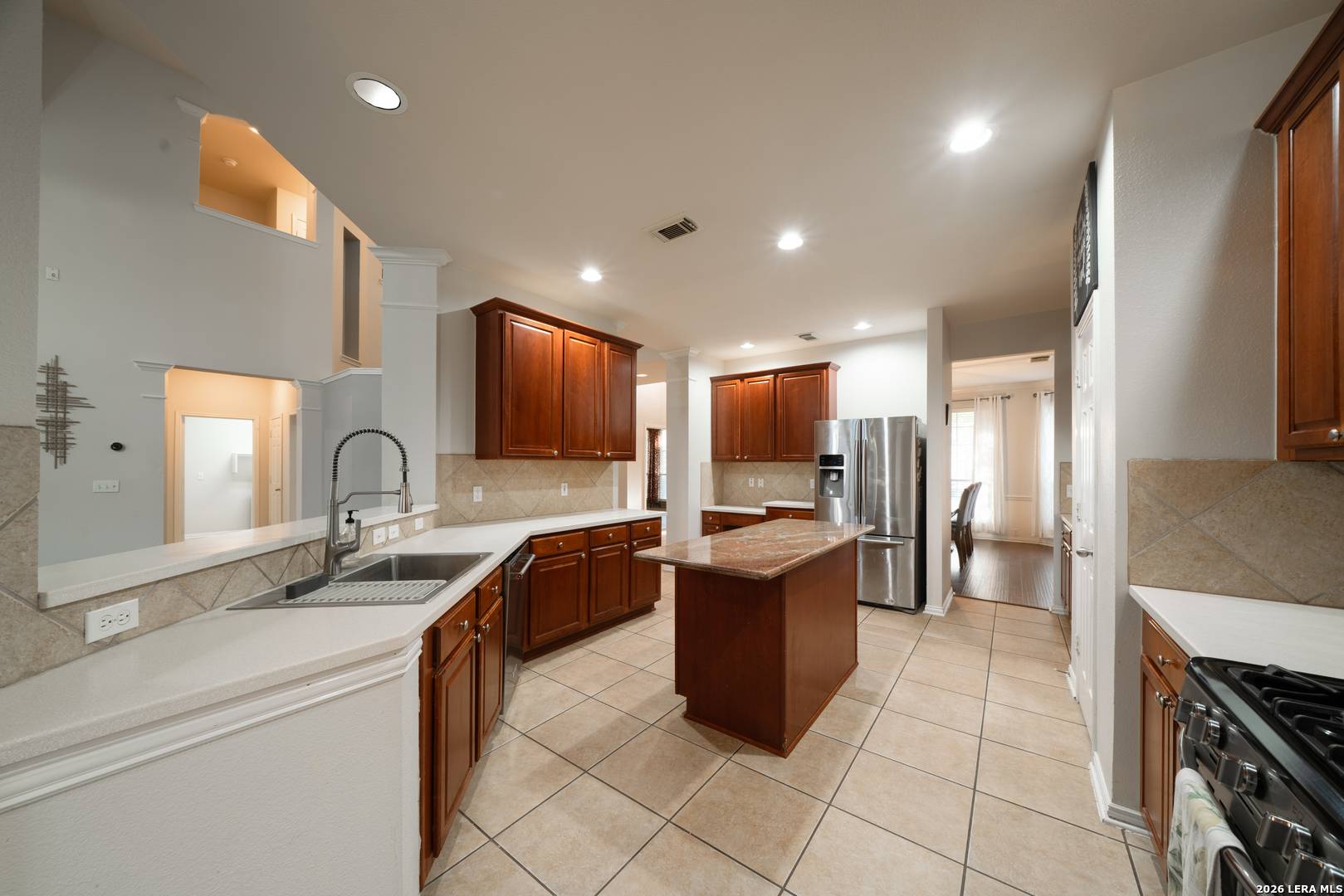 13034 Wild Heart Helotes, TX 78023 - Photo 14 of 49 a kitchen with granite countertop a sink and a stove top oven