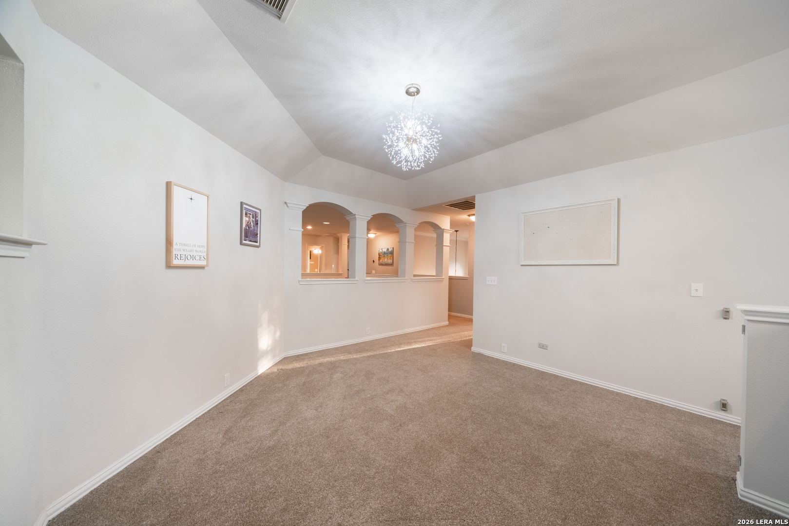 13034 Wild Heart Helotes, TX 78023 - Photo 27 of 49 an empty room with windows and chandelier
