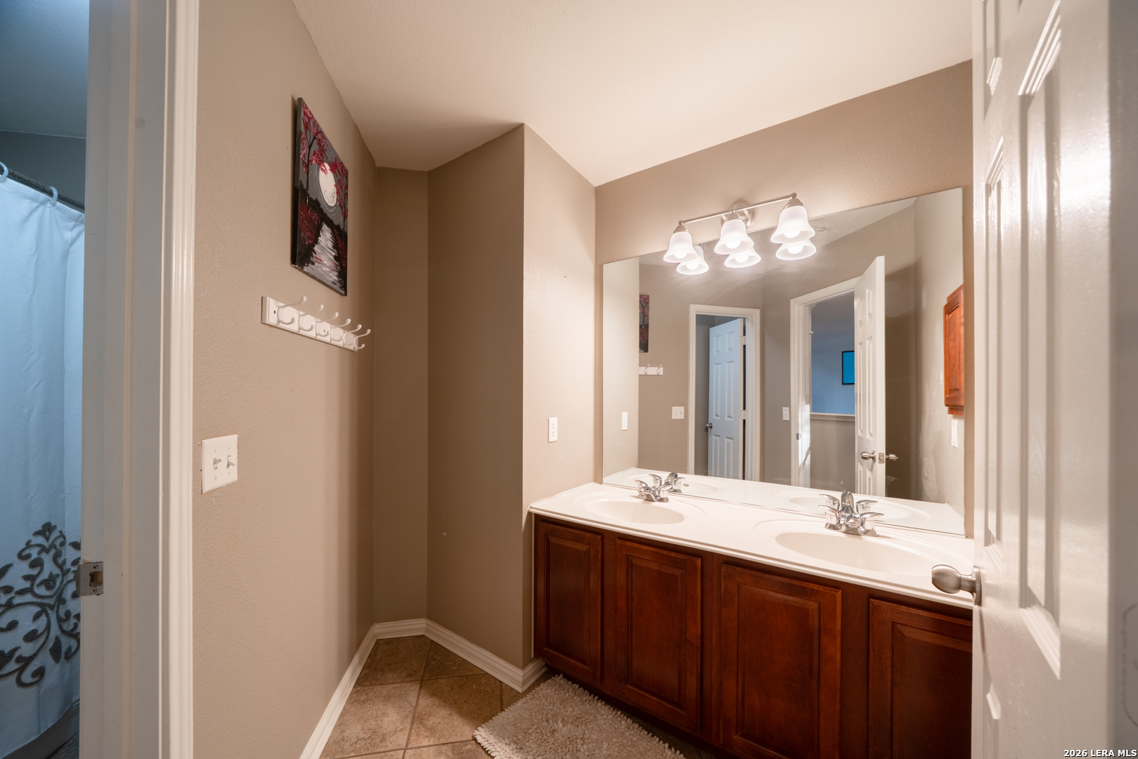 13034 Wild Heart Helotes, TX 78023 - Photo 29 of 49 a bathroom with a double vanity sink and a mirror