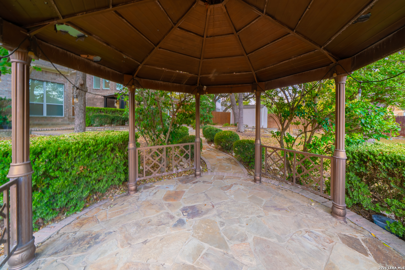 13034 Wild Heart Helotes, TX 78023 - Photo 38 of 49 a view of a patio with table and chairs under an umbrella with a big yard