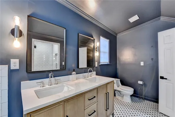 a bathroom with a sink a toilet and a large mirror